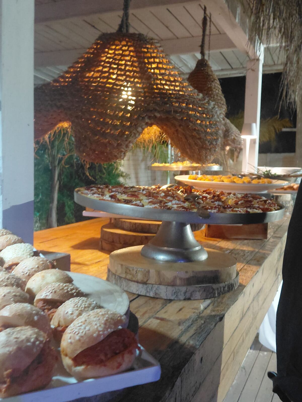 Buffet con pizza e panini gourmet su stand rustici